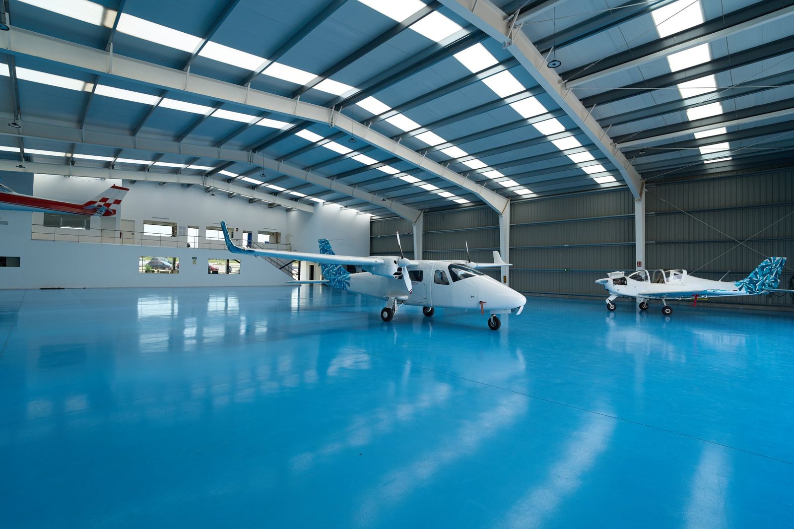 Blue high-gloss commercial epoxy floor in an aircraft hangar
