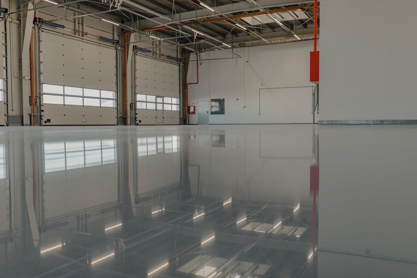 High-gloss gray epoxy warehouse floor in front of loading dock doors